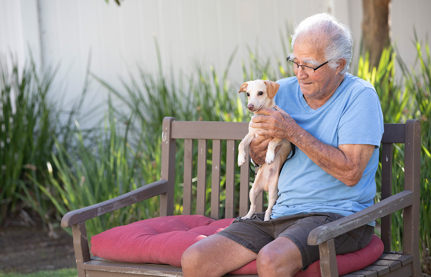 A person sitting on a bench with their dog.