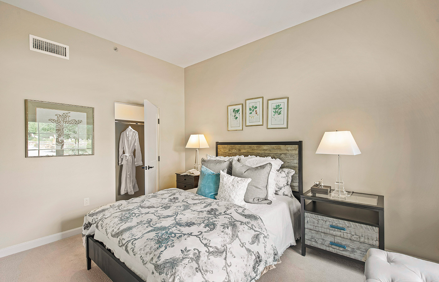 Furnished bedroom with bed, drawers, and soft lighting.