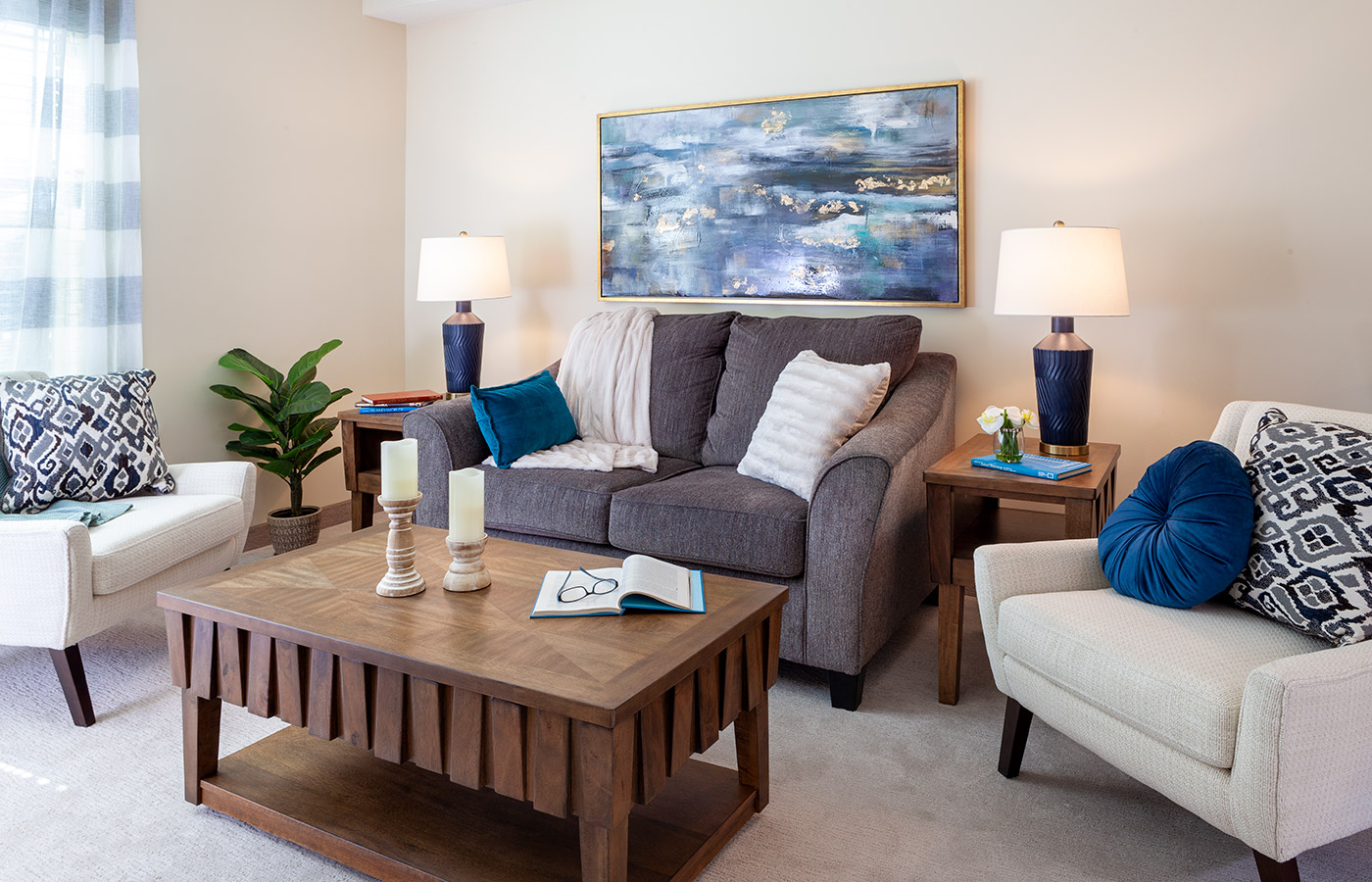 Furnished living room space with sofa, coffee table and chairs.