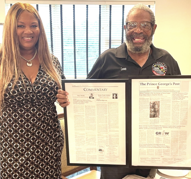 Vet-LSB Two people holding up a framed newspaper.