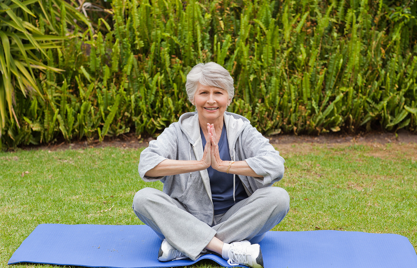 A resident sits on mat doing yoga.